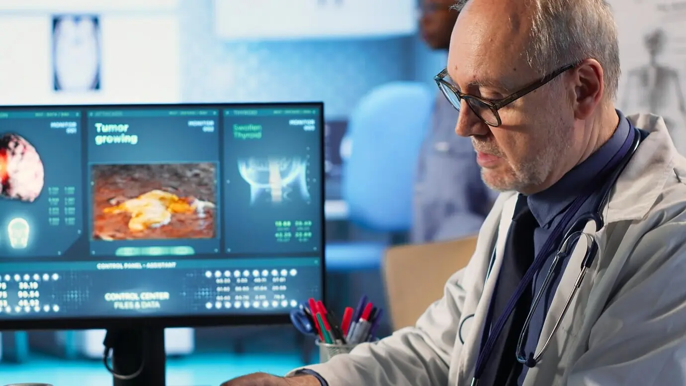 Ein Spezialist und eine ältere Frau besprechen eine Röntgenaufnahme zur Krebsvorsorge.